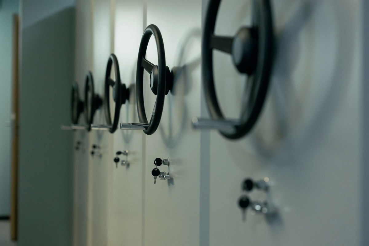 Three rental cabinets lined up against a plain wall: two mechanical reel-and-lever cabinets and one screen cabinet, fronts with no coin slot.