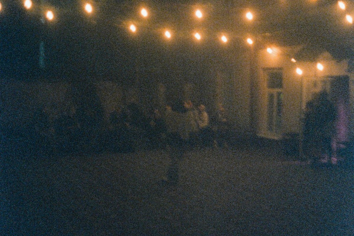 Dance floor under a hundred hanging lanterns, adults in smart-casual dress seen from behind.